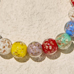 Pulseras de cristal coloridas que brillan en la oscuridad con motas doradas y crucifijo
