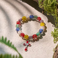 Pulseras de cristal coloridas que brillan en la oscuridad con motas doradas y crucifijo