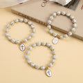 Élégant bracelet perlé en croix, blanc et doré : Une pure grâce au quotidien