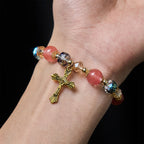 Bracelet perles roses en cristal et facettées avec crucifix doré : Une foi éblouissante pour votre style quotidien