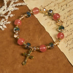 Bracelet perles roses en cristal et facettées avec crucifix doré : Une foi éblouissante pour votre style quotidien