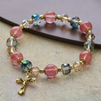 Bracelet perles roses en cristal et facettées avec crucifix doré : Une foi éblouissante pour votre style quotidien