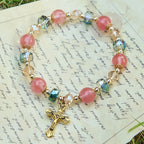 Bracelet perles roses en cristal et facettées avec crucifix doré : Une foi éblouissante pour votre style quotidien