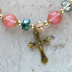 Bracelet perles roses en cristal et facettées avec crucifix doré : Une foi éblouissante pour votre style quotidien