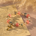 Bracelet perles roses en cristal et facettées avec crucifix doré : Une foi éblouissante pour votre style quotidien