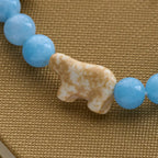 Bracelet en croix fait à la main « Ours polaire Perle bleue » : Sauvons nos ours polaires