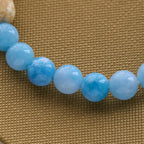 Bracelet en croix fait à la main « Ours polaire Perle bleue » : Sauvons nos ours polaires