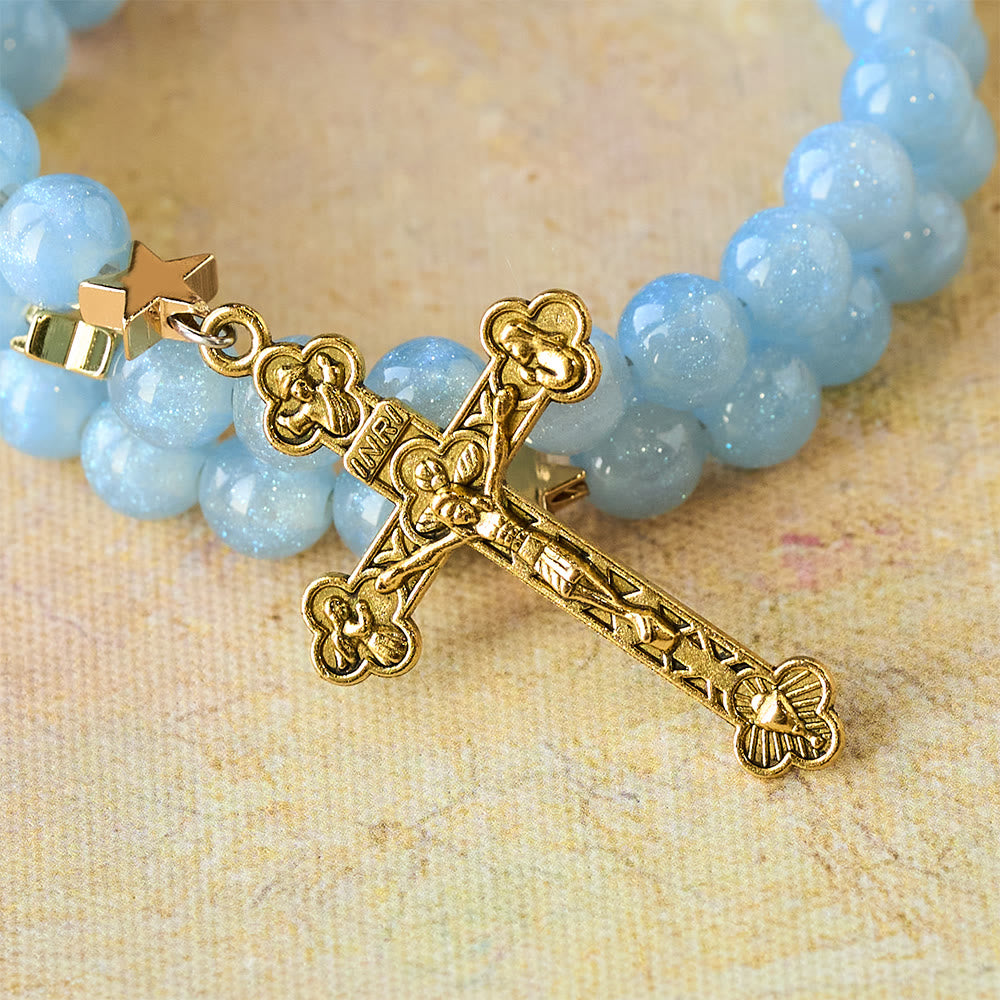 Pulsera enrollable de cuentas de cristal azul con espaciadores de estrella y crucifijo dorado
