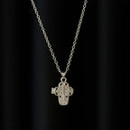 Collar con relicario en forma de cruz y filigrana intrincada: un símbolo de secreto sagrado y devoción