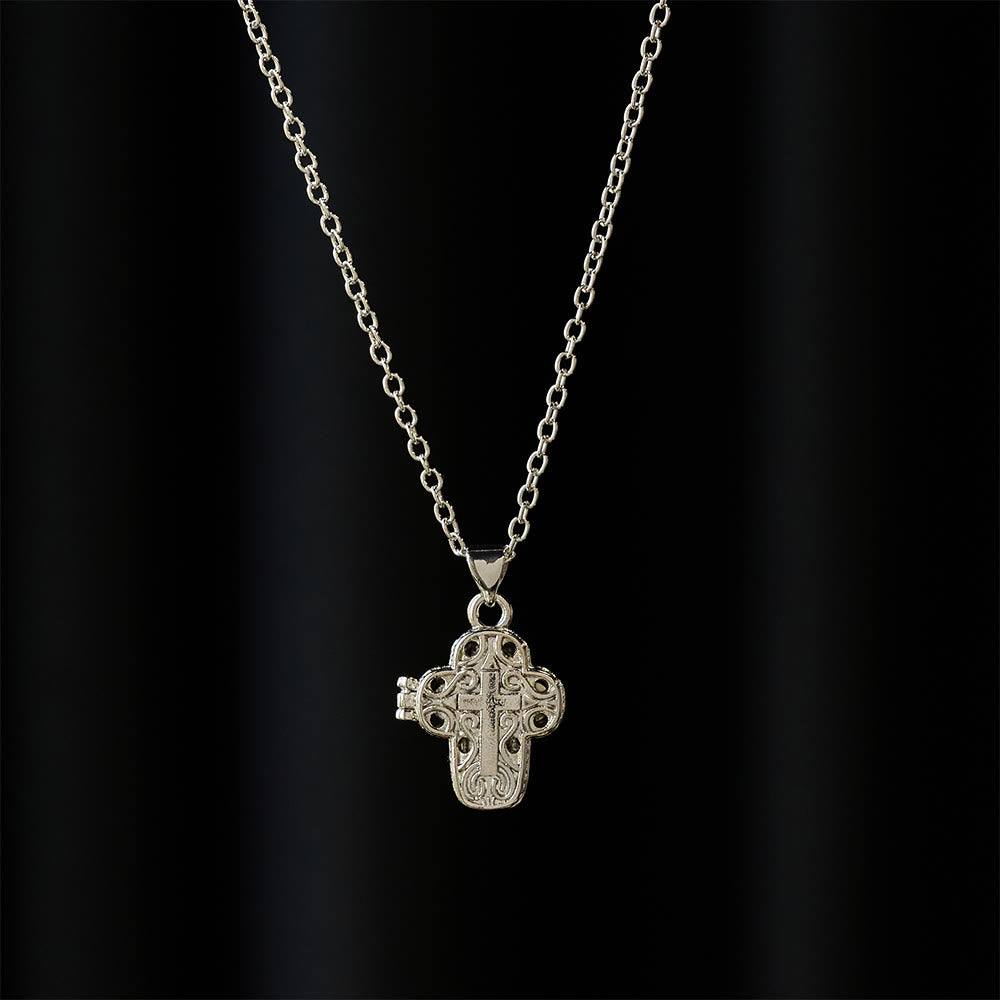 Collar con relicario en forma de cruz y filigrana intrincada: un símbolo de secreto sagrado y devoción